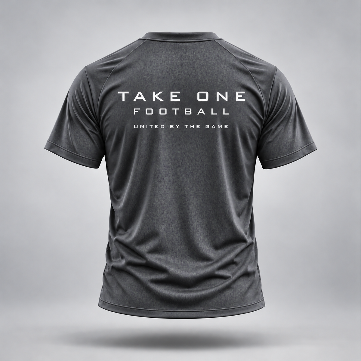 Take One Sportswear graphite gray Football Performance Tee, back view featuring white TAKE ONE FOOTBALL lettering and United By The Game graphic.