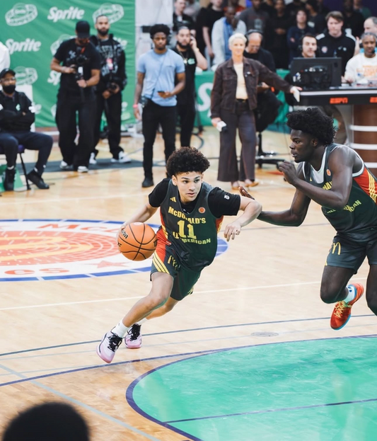 Darius Bivins dribbling past a defender during the 2026 McDonald's All-American basketball festivities, featured in a Take One Sportswear ROAM Series athlete spotlight.