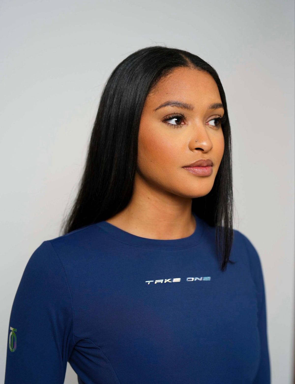 Three-quarter portrait of a woman wearing the navy Concord FlightKnit Long Sleeve Top from Take One Sportswear.