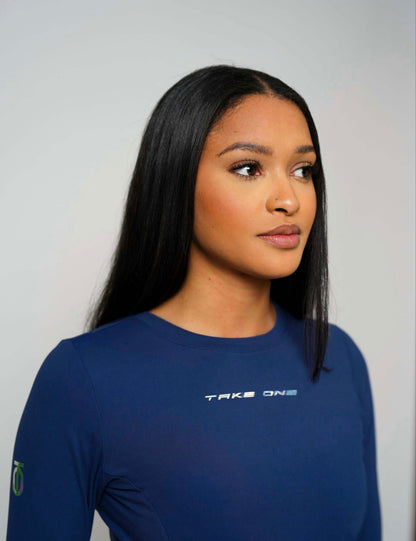 Three-quarter portrait of a woman wearing the navy Concord FlightKnit Long Sleeve Top from Take One Sportswear.