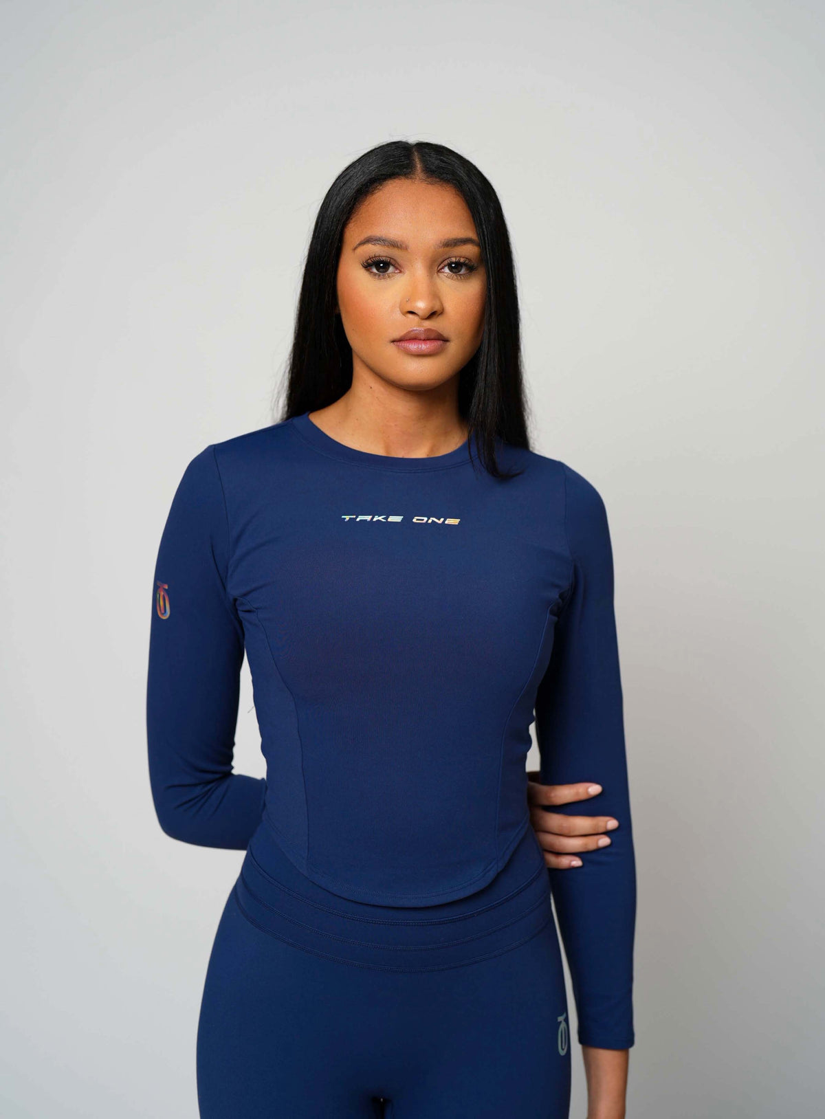 Woman modeling the navy Concord FlightKnit Long Sleeve Top by Take One Sportswear, front view with matching navy leggings.