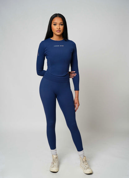 Front view of woman modeling navy blue Take One Sportswear Concord High-Waisted Leggings with a matching navy performance long-sleeve top.