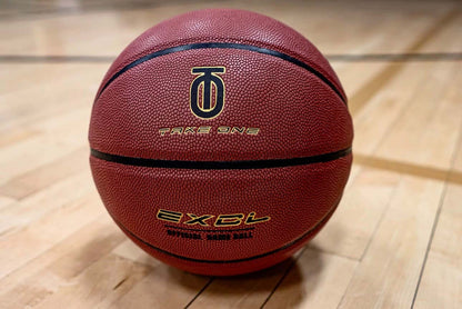 Take One EXCL Basketball photographed from an alternate angle on an indoor basketball court floor.