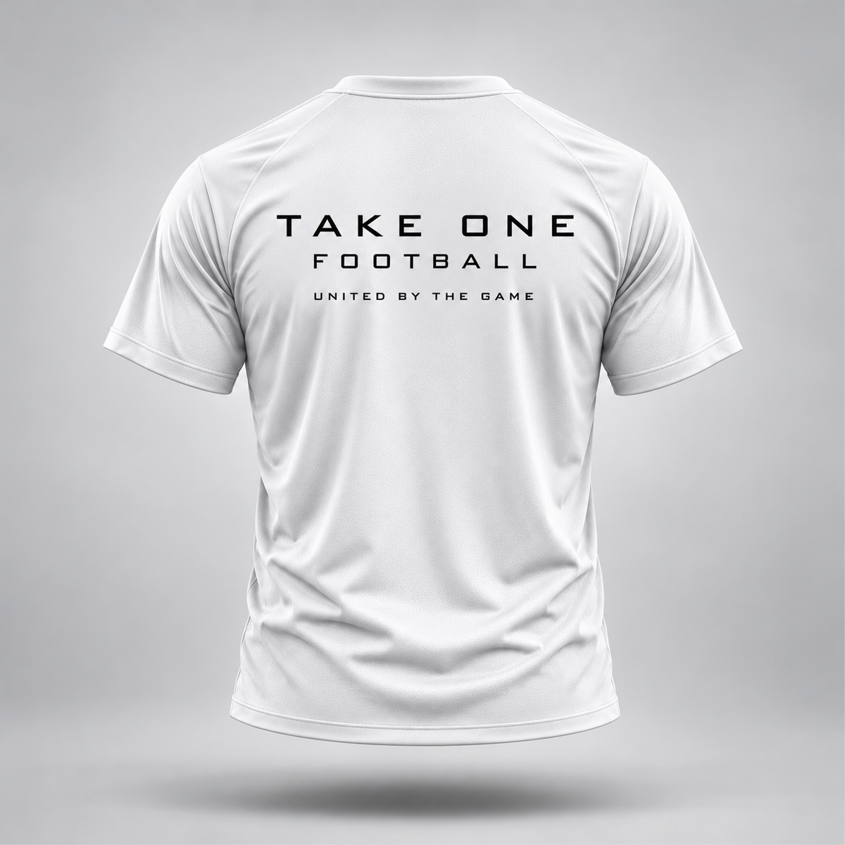 Take One Sportswear white Football Performance Tee back view featuring black TAKE ONE FOOTBALL lettering and United By The Game graphic.