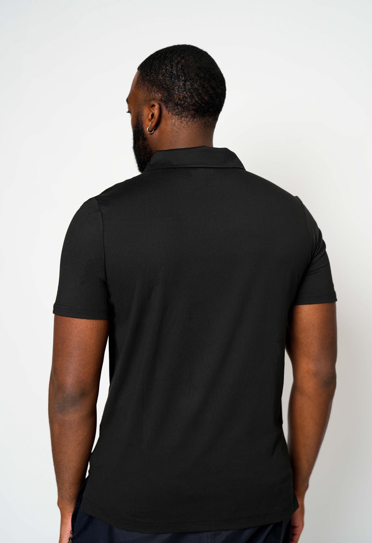 Back view of black Take One Sportswear Journey Performance Polo showing the plain black fabric and polo collar.