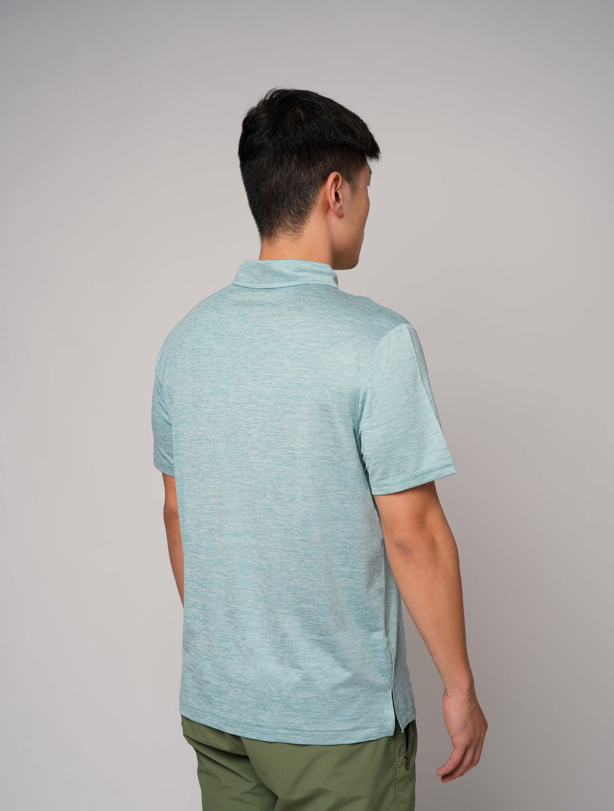 Rear view of male model wearing a light blue Take One Sportswear Journey Performance Polo with short sleeves and a classic collar.