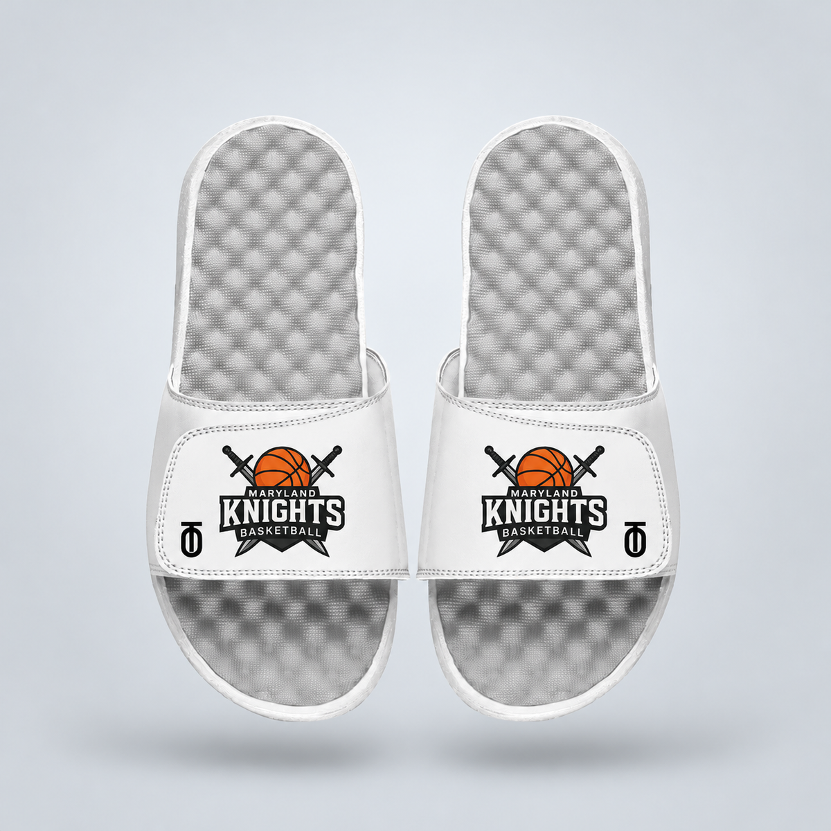 Top view of white Maryland Knights AAU Basketball Mantra Slides by Take One Sportswear, featuring the Maryland Knights  logo on the straps and textured grey footbeds. Neutral grey studio background with a subtle floating shadow.