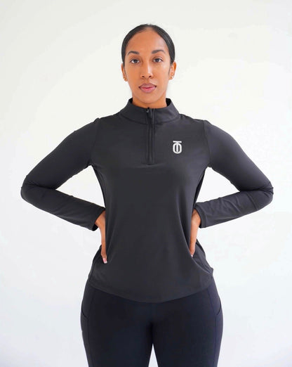 Full front view of a woman wearing the black Take One Therma-FIT fitted long-sleeve performance top and matching black leggings with hands on hips.